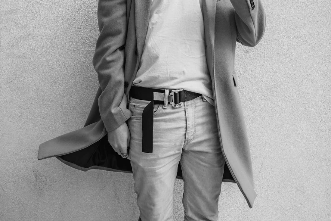Accessories — a camel overcoat worn over tailoring, with belt detail