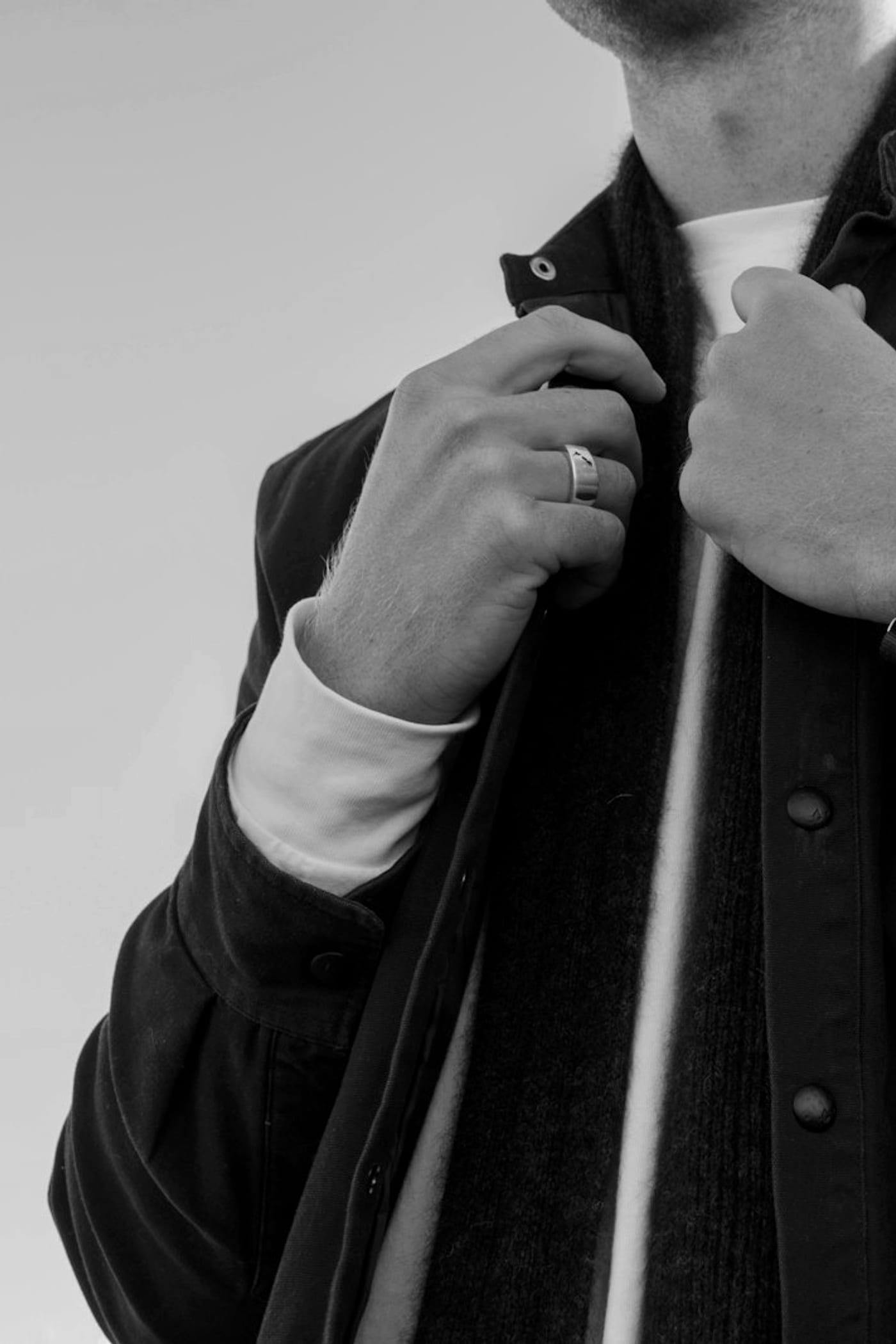 Close study of a man adjusting a jacket, low light