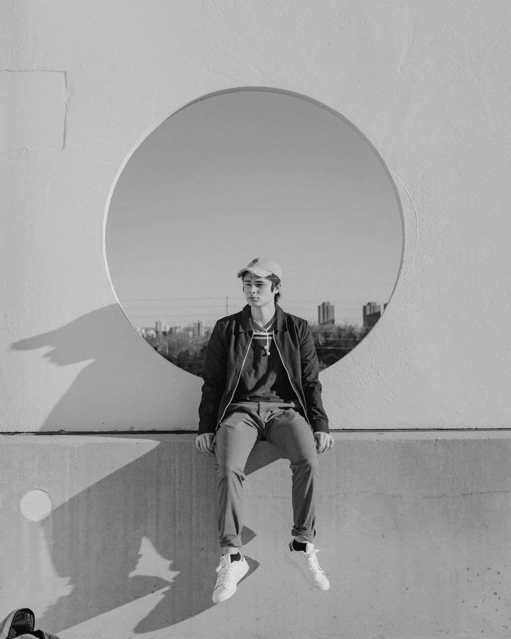 A figure seated within a circular architectural opening